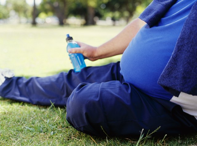 side profile of a mid adult man holding a water bottle in a park