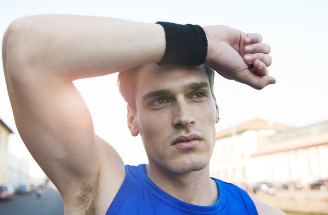 Tired athlete wipes the sweat from his forehead