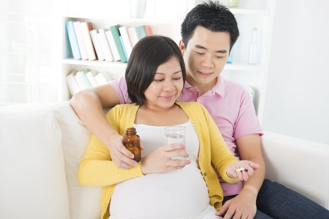 Asian pregnant woman having medicine at home