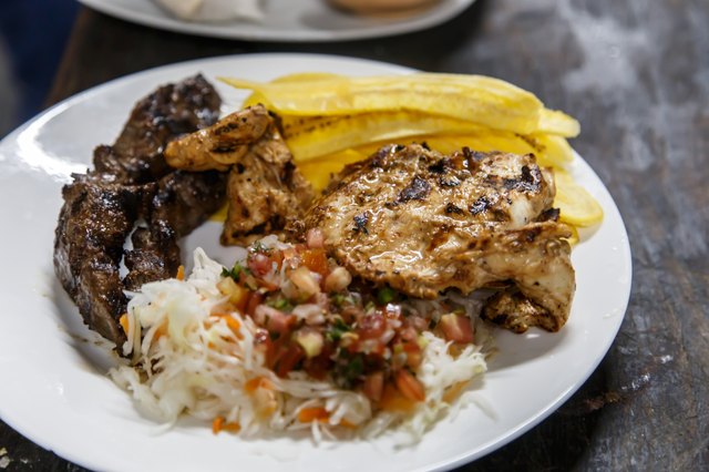 traditional nicaraguan cuisine, roast meat, salad and fried banana.