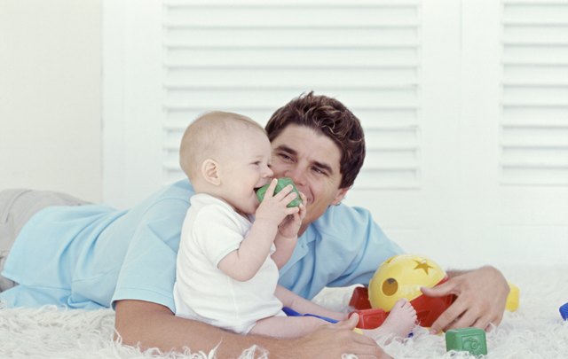 Father playing with baby (6-12 months), indoors