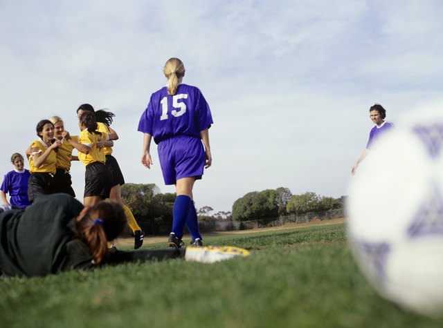 Young women footballers on pitch, rejoicing victory, surface view