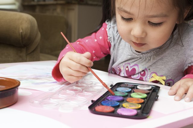 Little Asian girl learning to paint