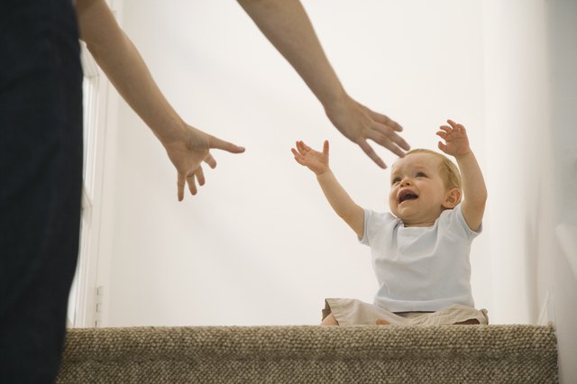 Crying baby reaching for mother