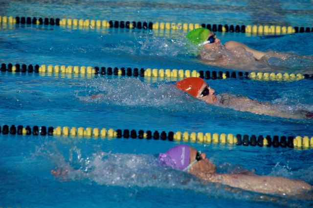 Three male swimmers in a race