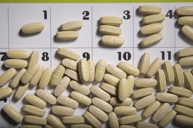 Pills scattered on a calendar page