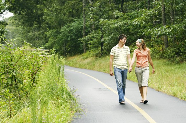 Couple holding hands while walking along path