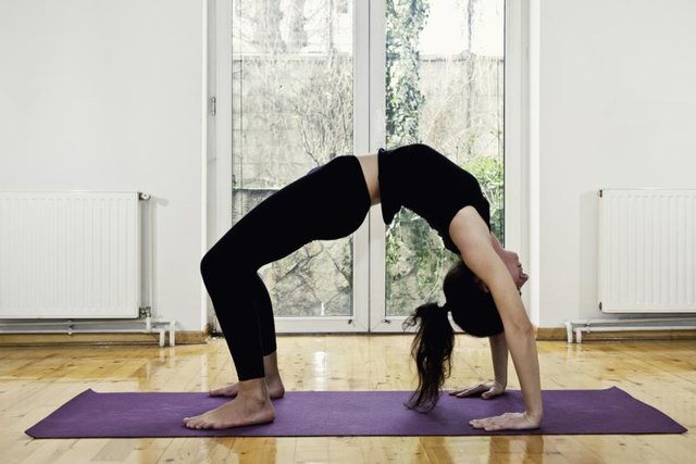Woman doing Yoga at home - Bridge position. Slightly toned image