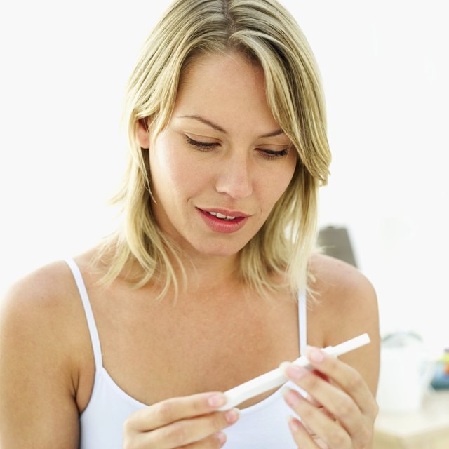 woman looking at pregnancy test kit