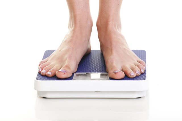 Woman feet and weight scale isolated on white background