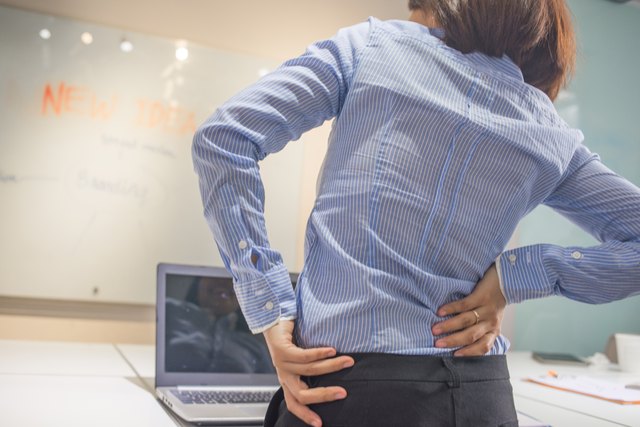 Woman doing some simple exercise for her back at office