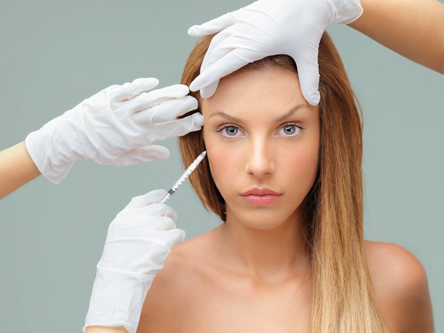 young woman with doctor hands injecting botox
