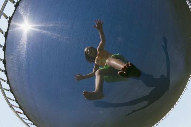 Low angle view through trampoline of girl