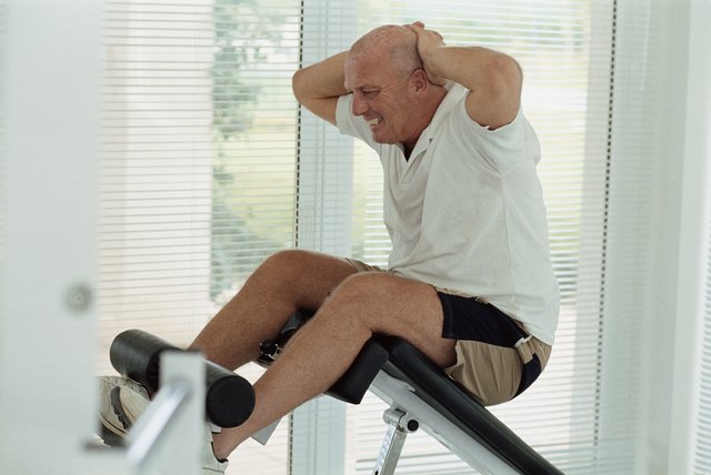 Senior man doing sit-ups in a gym