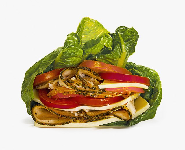 Close up of meat, tomatoes and cheese wrapped in lettuce