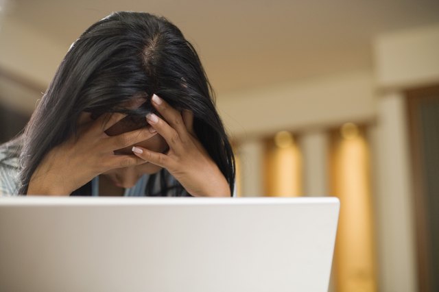 Woman stressed out in front of laptop computer