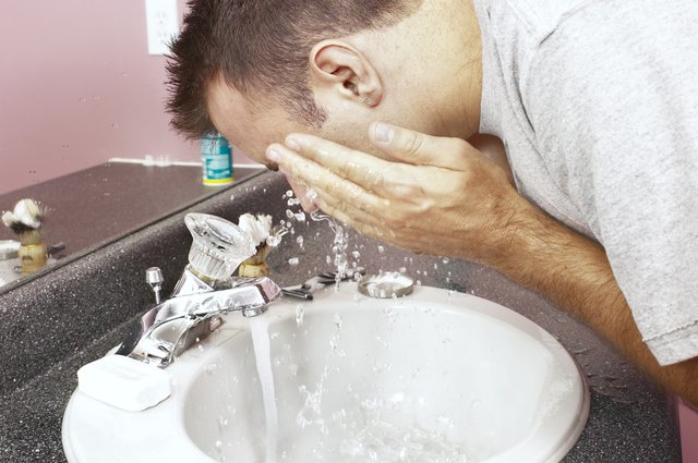 Man washing face at sink