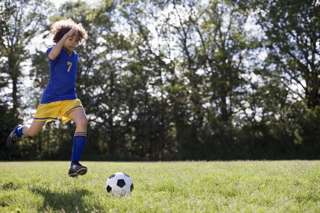 Boy kicking soccer ball