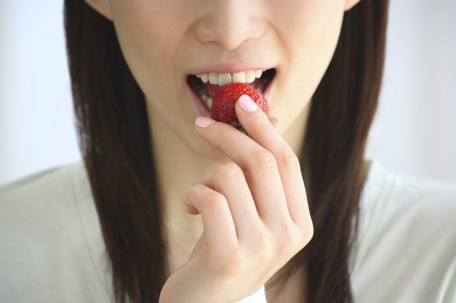 Close Up Image of a Woman Eating a Strawberry, Front View