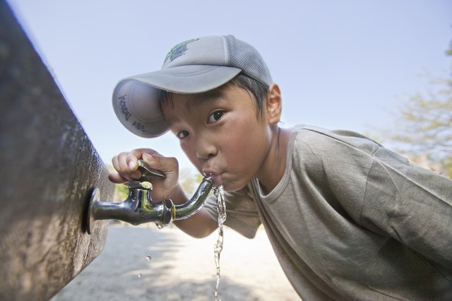 Boy drinking water from faucet, Japan