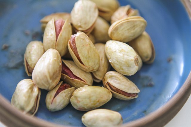 Lemon and safran roasted salted pistachios in a blue bowl