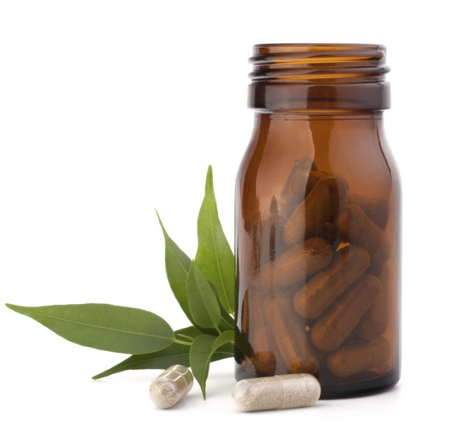 Herbal drug capsules in brown glass bottle. Alternative medicine