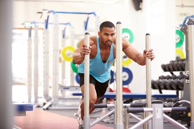Muscular man working out using equipment at a gym