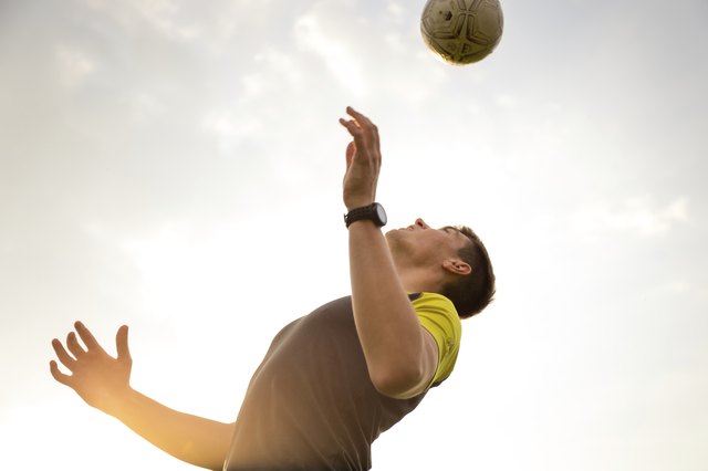 Young, male man playing soccer on a beach