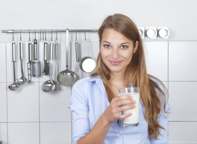 Young woman with milkshake in her kitchen
