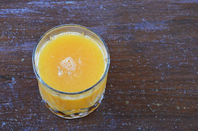 glass of orange juice on wooden table