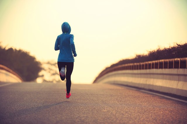young fitness woman trail runner running on city road