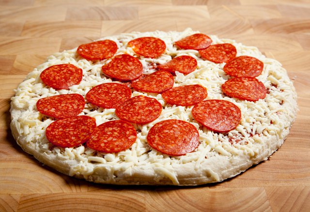 Frozen pepperoni pizza on a cutting board