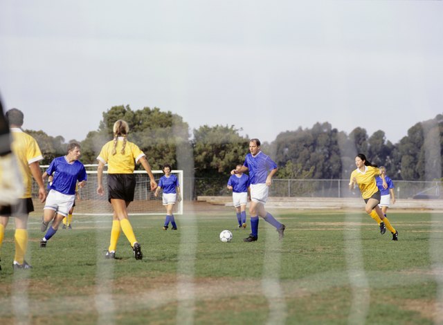 Mixed football team playing on grass pitch