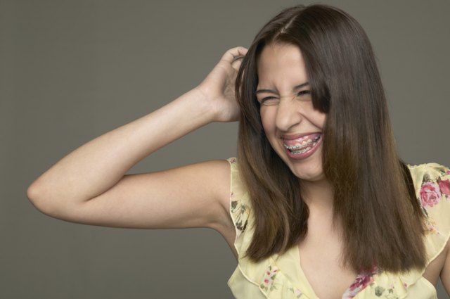 Young woman scratching her head and laughing
