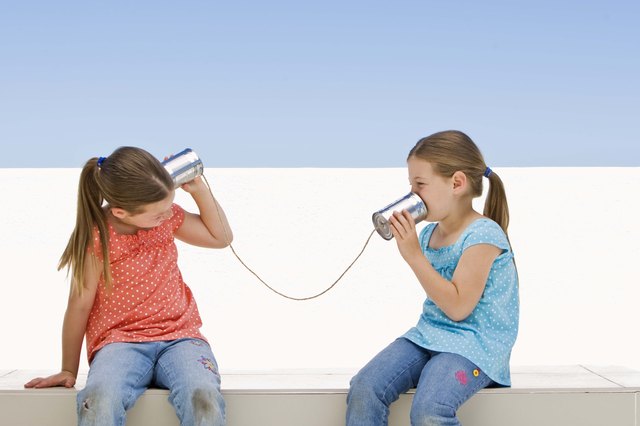 Twin girls with tin can telephone