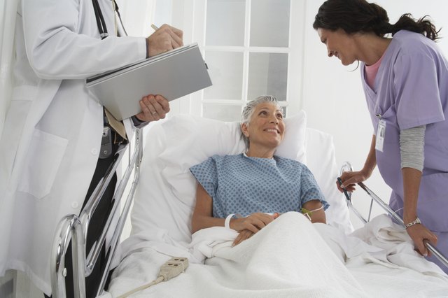 Patient in hospital bed speaking to Doctor and Nurse