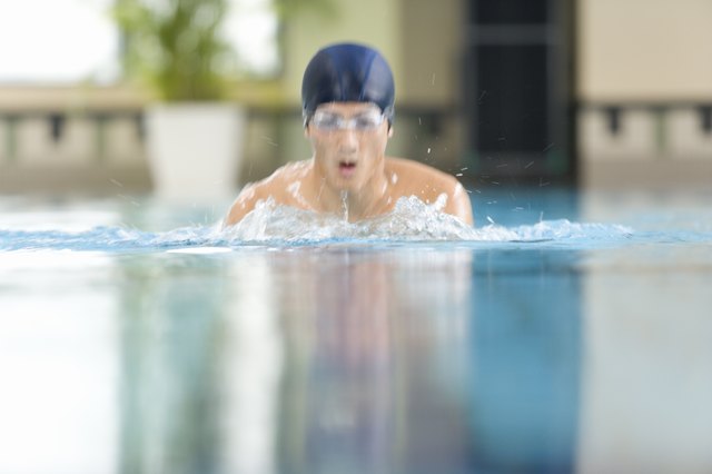 Man swimming in the pool, front view, defocused