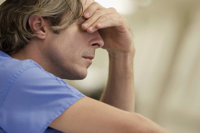 Close-up of a male doctor with his hand on his head