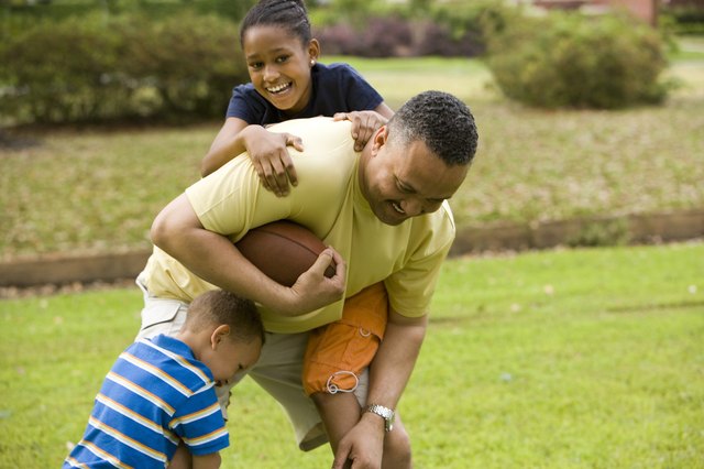 Father playing with their children at park