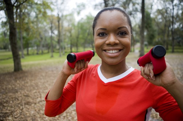 Portrait of a young woman in sports clothing exercising with exercising equipment on ground