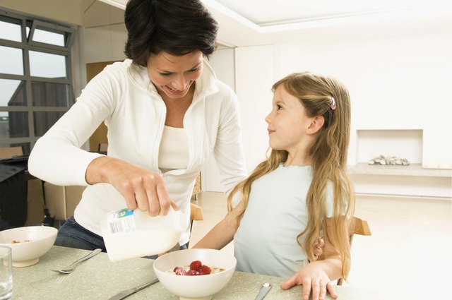 Close-up of a young woman serving breakfast to her daughter