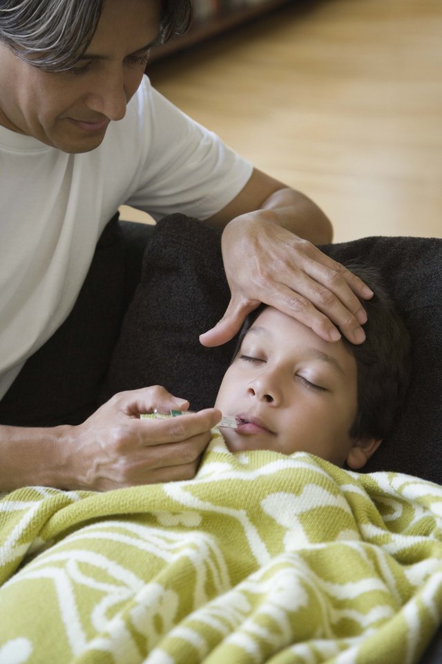 Father taking temperature of sick son