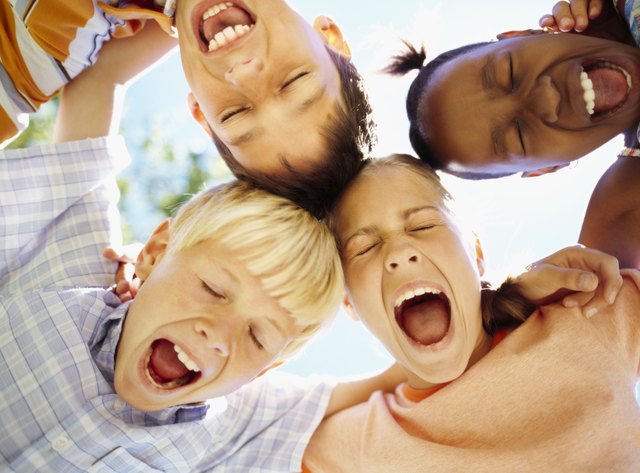 low angle view of children standing in a huddle with their mouth open