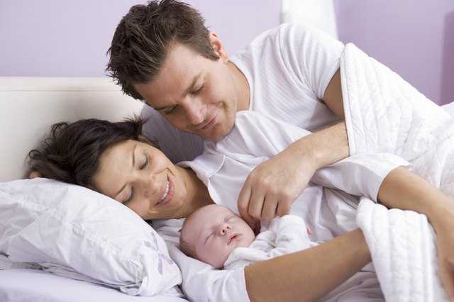 Parents in bed with sleeping baby