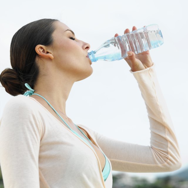 Low angle side view of a woman drinking water from a bottle