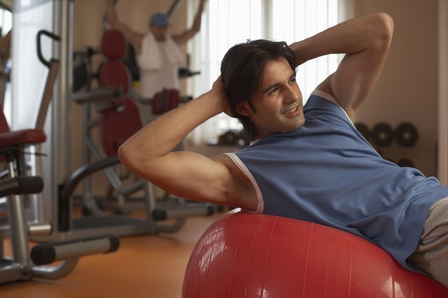Man exercising on exercise ball in gym