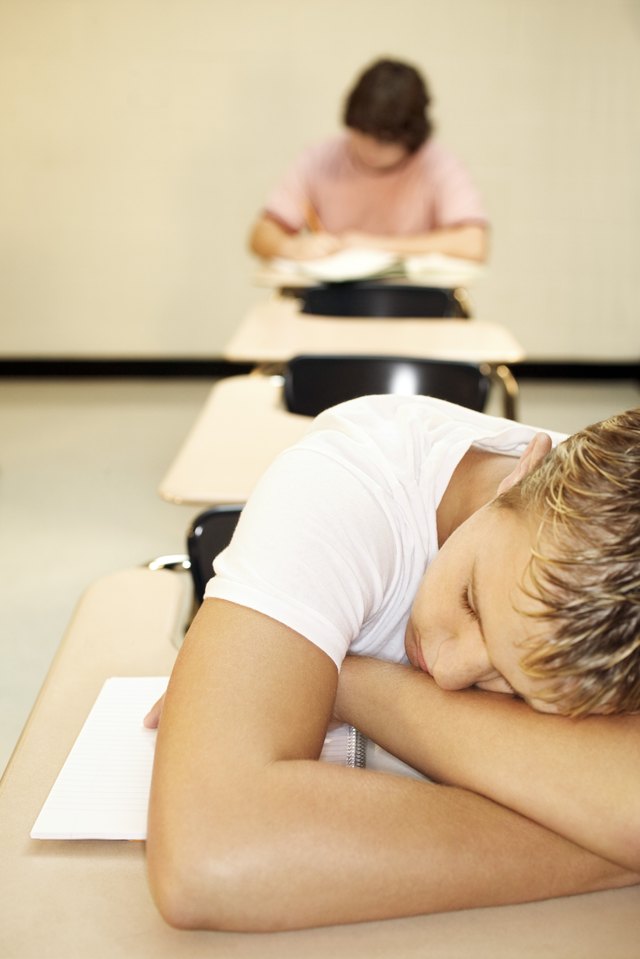 Teenage boy sleeping at desk