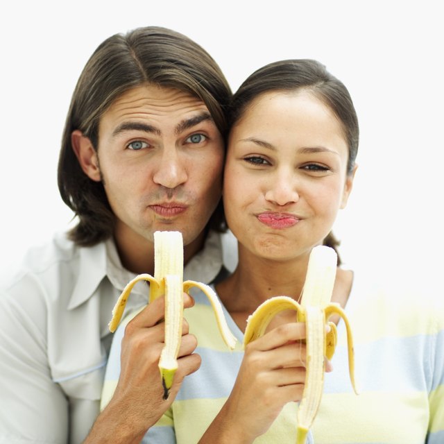 portrait of a young couple eating bananas