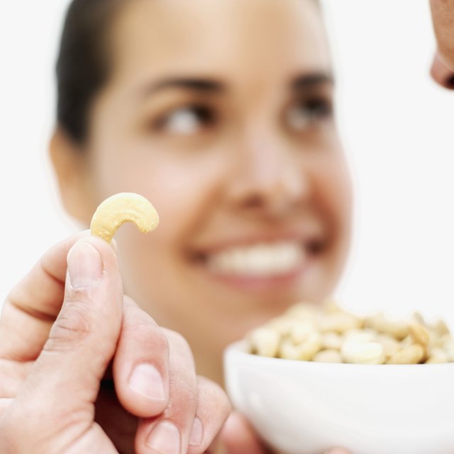 Close-up of a cashew nut in a man's hand