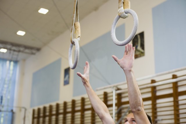 Male gymnast reaching for rings